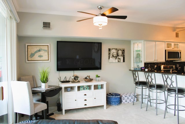 living room with light carpet, ceiling fan, and ornamental molding