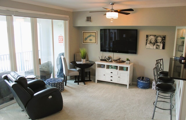 living room with ceiling fan, light carpet, and ornamental molding