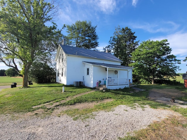 exterior space with a front lawn, covered porch, and central AC unit