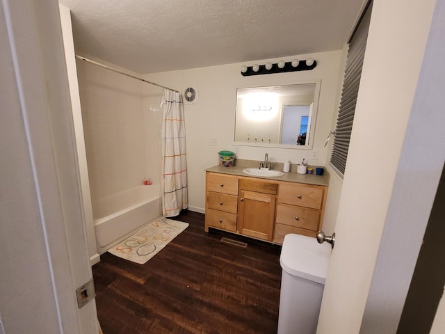 bathroom featuring vanity, shower / bath combination with curtain, a textured ceiling, and hardwood / wood-style flooring