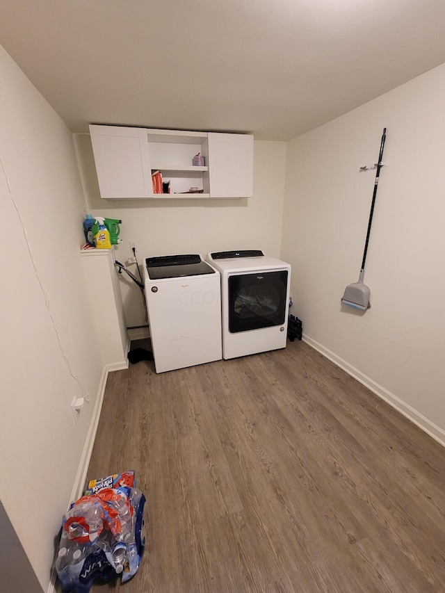 clothes washing area featuring light hardwood / wood-style floors, cabinets, and separate washer and dryer