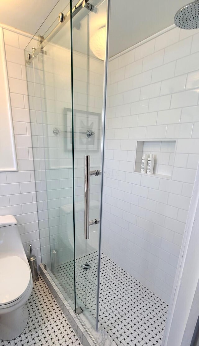 bathroom with tile patterned flooring, toilet, and walk in shower