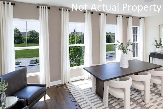 dining room with dark wood-style flooring and baseboards