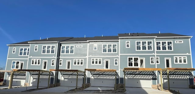 back of house featuring a garage and driveway