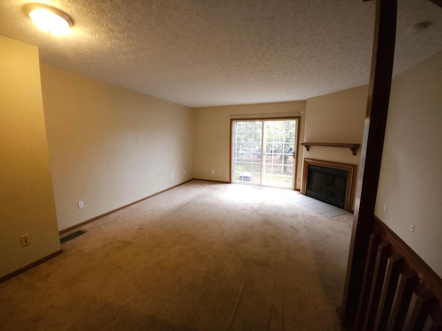 unfurnished living room with light colored carpet and a textured ceiling