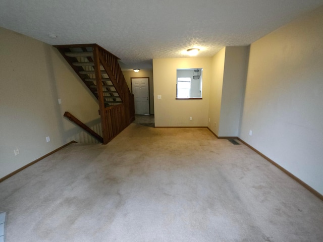 carpeted empty room featuring a textured ceiling