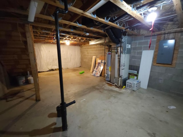 basement featuring electric panel and water heater