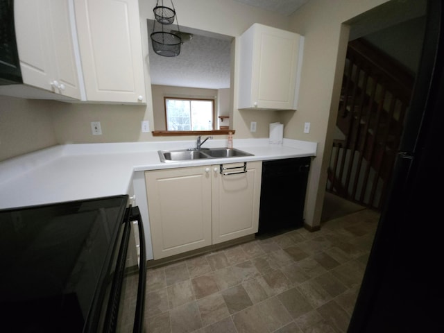 kitchen with a textured ceiling, black appliances, white cabinets, and sink