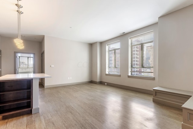 unfurnished living room with wine cooler, plenty of natural light, and light wood-type flooring