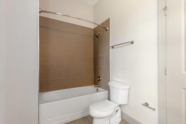 bathroom featuring toilet and tiled shower / bath