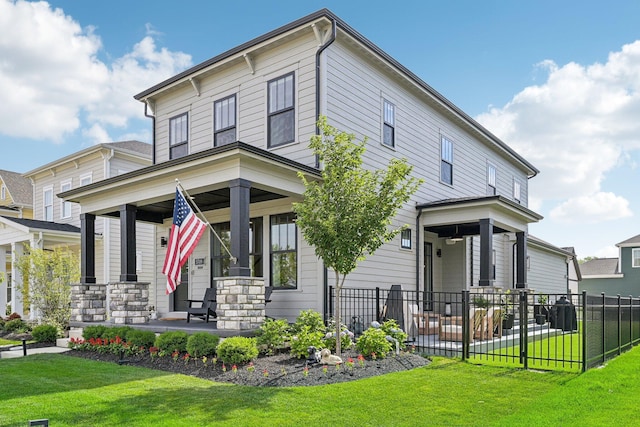 italianate-style house featuring covered porch, fence, and a front lawn