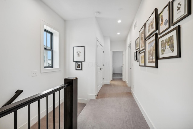 hallway featuring visible vents, baseboards, carpet, an upstairs landing, and recessed lighting