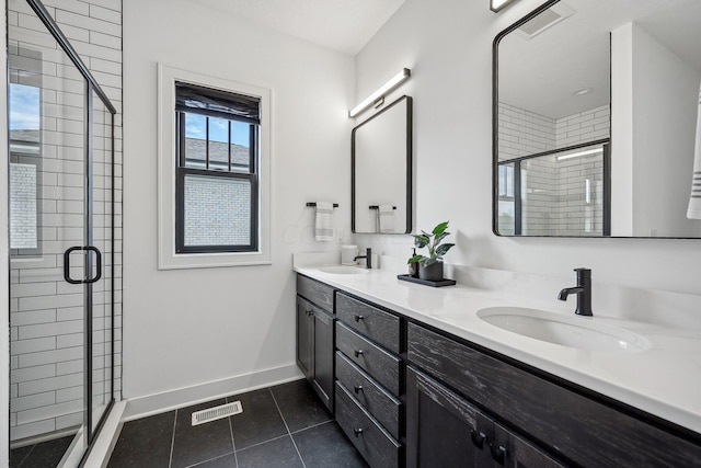 bathroom featuring visible vents, a sink, a shower stall, tile patterned flooring, and baseboards