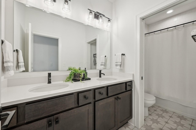 bathroom with toilet, double vanity, a sink, and tile patterned floors