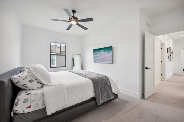 bedroom featuring baseboards, ceiling fan, visible vents, and light colored carpet