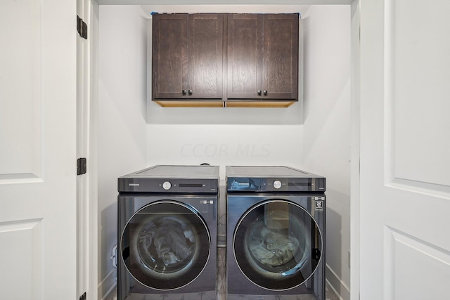 washroom featuring cabinet space and washer and clothes dryer