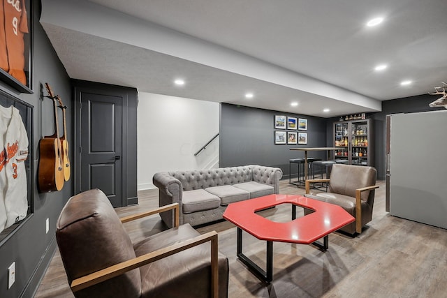 living room with light wood finished floors, baseboards, and recessed lighting