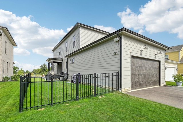 view of side of home with aphalt driveway, a lawn, an attached garage, and fence