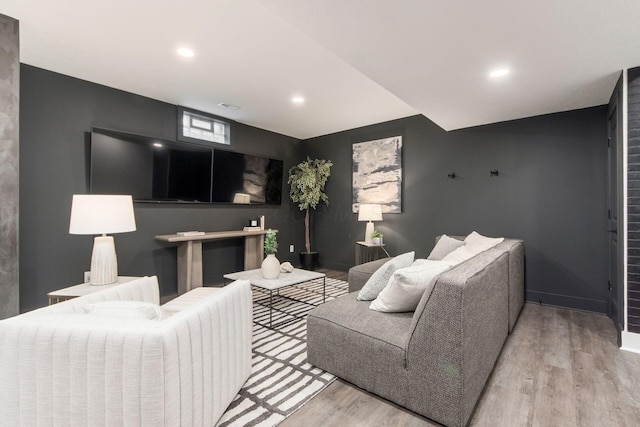 living room with light wood finished floors, baseboards, and recessed lighting