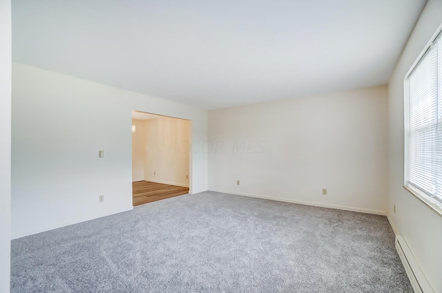 spare room with carpet and baseboard heating