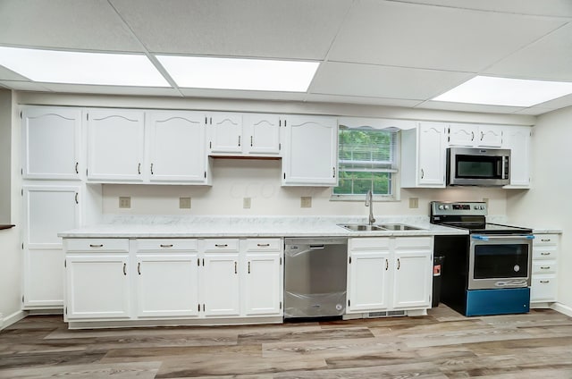 kitchen featuring white cabinets, sink, appliances with stainless steel finishes, and light hardwood / wood-style flooring