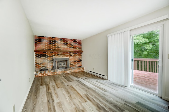 unfurnished living room with a wood stove, light hardwood / wood-style flooring, and a baseboard radiator