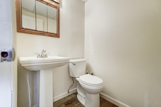 bathroom with hardwood / wood-style floors, toilet, and sink