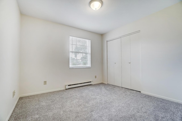 unfurnished bedroom featuring carpet flooring, baseboard heating, and a closet