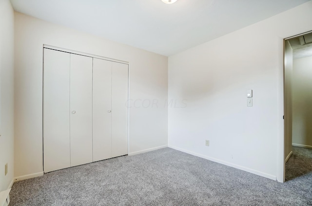 unfurnished bedroom with carpet and a closet