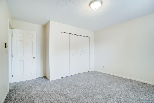 unfurnished bedroom featuring carpet flooring and a closet