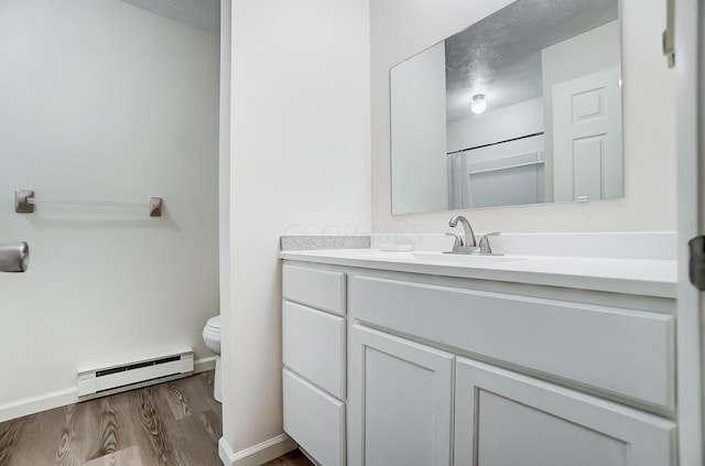 bathroom with a shower with curtain, vanity, baseboard heating, wood-type flooring, and toilet