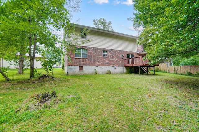 rear view of property with a wooden deck and a lawn