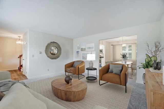 carpeted living room with a notable chandelier