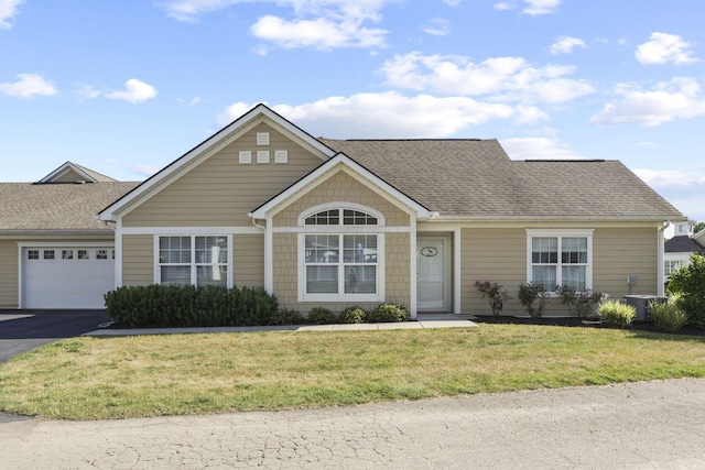 view of front of home with cooling unit, a garage, and a front lawn