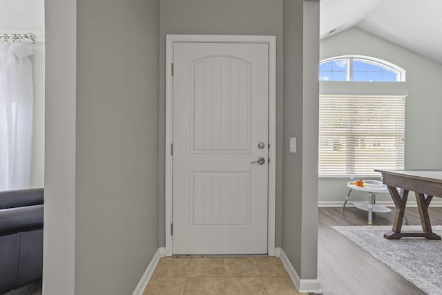 doorway to outside featuring lofted ceiling and light wood-type flooring