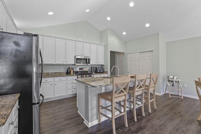 kitchen with white cabinetry, sink, dark hardwood / wood-style floors, an island with sink, and appliances with stainless steel finishes