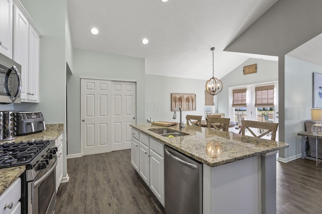 kitchen with lofted ceiling, white cabinets, dark hardwood / wood-style floors, an island with sink, and stainless steel appliances