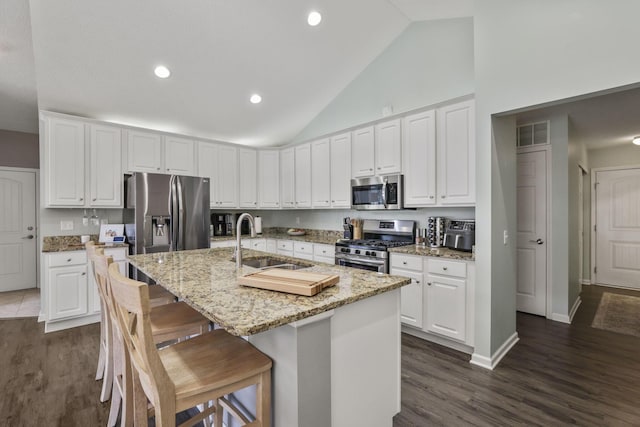 kitchen with sink, white cabinetry, a kitchen island with sink, and appliances with stainless steel finishes