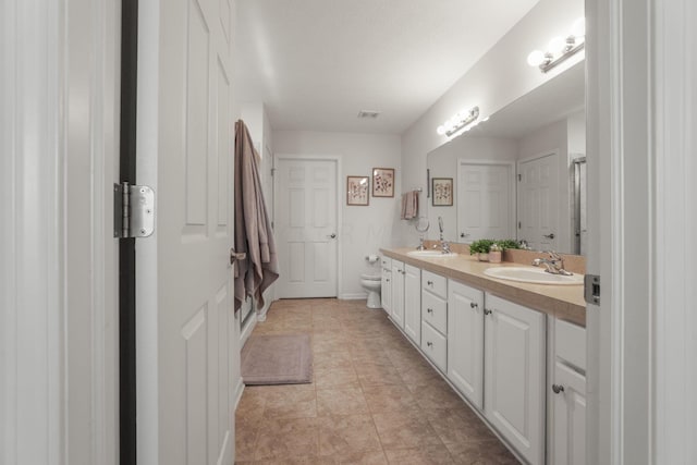 bathroom featuring tile patterned floors, vanity, and toilet