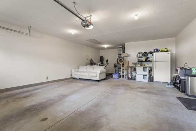 garage featuring white fridge and a garage door opener