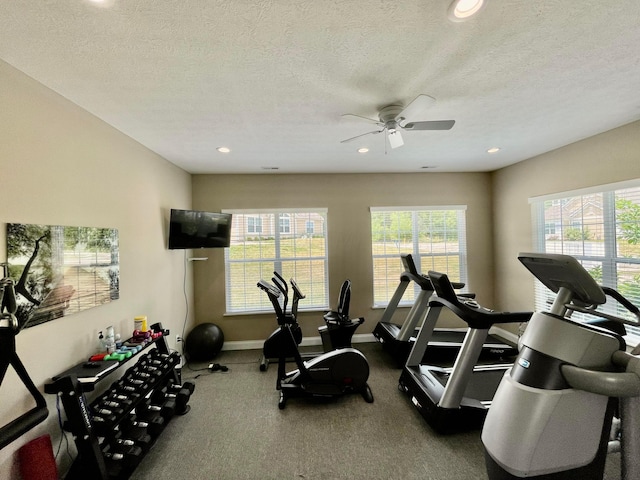 exercise room featuring ceiling fan and a textured ceiling