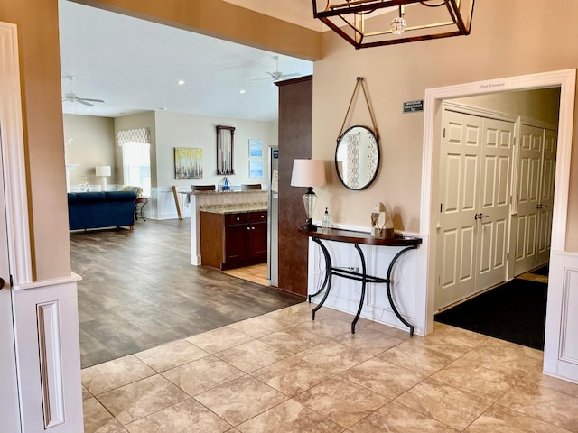 foyer entrance with ceiling fan and light hardwood / wood-style floors