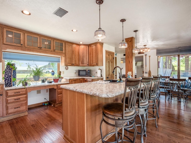 4 Cadillac Dr, Senecaville, OH 43780 - kitchen with pendant lighting, plenty of natural light, dark hardwood / wood-style flooring, and an island with sink