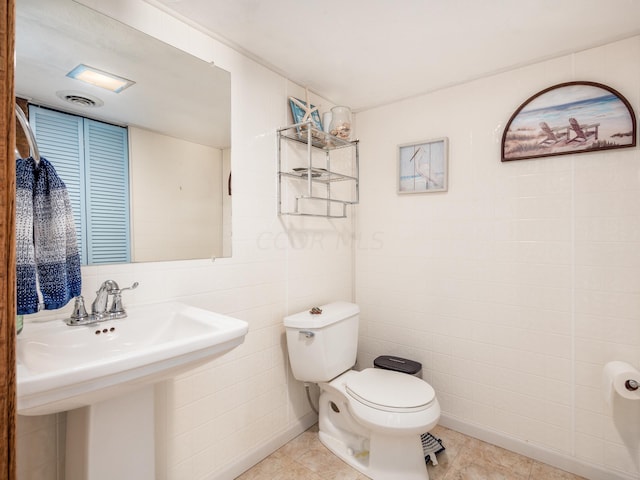 4 Cadillac Dr, Senecaville, OH 43780 - bathroom featuring sink, tile patterned flooring, tile walls, and toilet