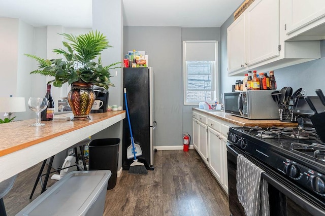 kitchen with white cabinets, stainless steel appliances, and dark wood-type flooring