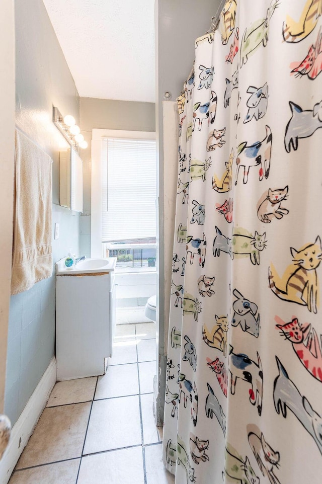 bathroom featuring tile patterned floors, curtained shower, vanity, and toilet