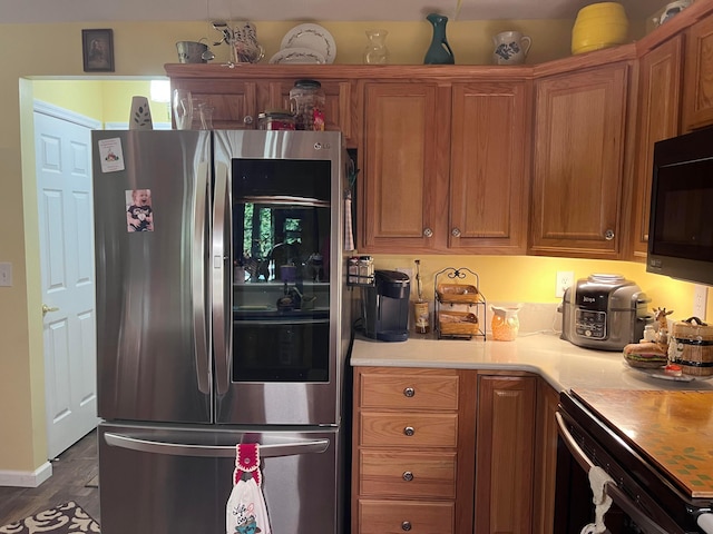 kitchen featuring stainless steel fridge and dark hardwood / wood-style flooring