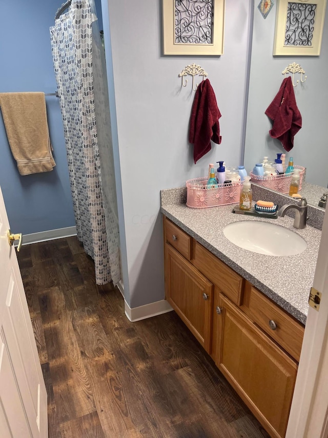 bathroom featuring hardwood / wood-style floors, vanity, and walk in shower