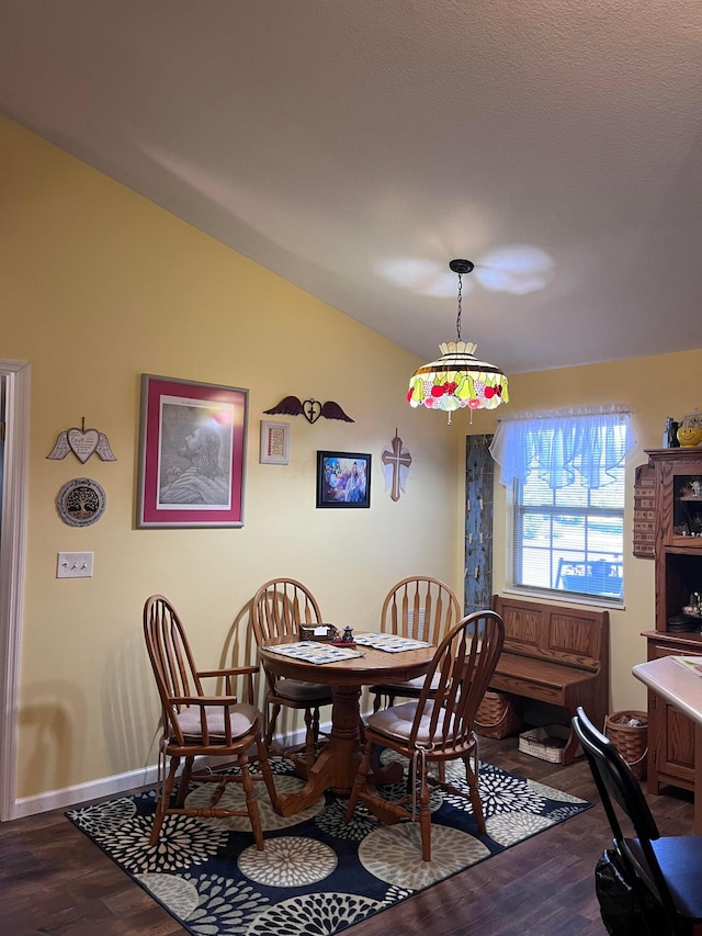 dining room with wood-type flooring and vaulted ceiling