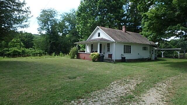 view of side of home with a lawn and a porch